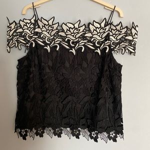 It’s a black and white off shoulder top with an embroidered flower design.